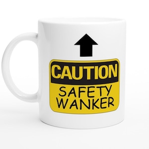 Könnte beinhalten: Weiße Keramiktasse mit einem gelben und schwarzen Warnschild mit der Aufschrift "CAUTION SAFETY WANKER".