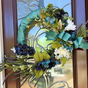 Year round all seasons Farm house wreath wrapped with turquoise ribbon.