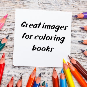 May include: A white card with the text "Great images for colouring books" on a wooden background with coloured pencils around the card.