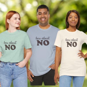May include: Three people wearing t-shirts with the phrase "how about NO" in a dark brown font. The shirts are in light green, light blue, and off-white colours. The background is a blurred green.