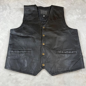 May include: Black leather vest with a patchwork design. The vest has a V-neck, two front pockets, and gold-colored buttons. The tag reads "GENUINE LEATHER".