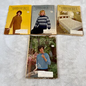 May include: Five vintage copies of "The Workbasket" magazine. The covers display women in knitted clothing and home decor. The magazines are in various colours, including yellow, grey, and green, with the magazine title in a bold, serif font.