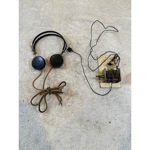 Radio de cristal antigua con auriculares de época y condensador de sintonización variable.