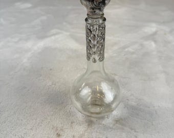 Frasco de perfume vintage em vidro transparente com detalhes prateados e tampa, 15 cm (6 polegadas) de diâmetro.