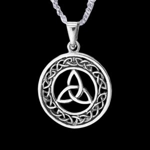 May include: Silver Celtic knot pendant necklace with a circular design featuring a trinity knot. The pendant is detailed with intricate knotwork and hangs from a silver chain.