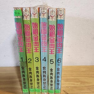 May include: A collection of six manga books, volumes 1-6, bound together. The spines are green, blue, and orange, with Japanese text and illustrations of a character's face. The books are wrapped in clear plastic and sit on a light wooden surface.