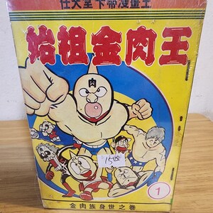 May include: A vintage Japanese comic book titled "Kinnikuman" (Muscle Man) in a yellow, red, and blue color scheme. The cover features a muscular cartoon character with a fist raised, surrounded by other characters. The text on the cover is in Japanese.