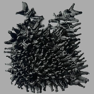 May include: A black and white abstract sculpture made of many small, repeating shapes. The sculpture is made of a material that looks like metal or plastic.