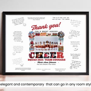 May include: A white framed print featuring a collage of cheerleaders in red and white uniforms. The print includes the text "Thank you! For a great season!" and "Cheer Squad 2025 - Team Cougars - Marie Anne Johnson - New Era Academy High School".