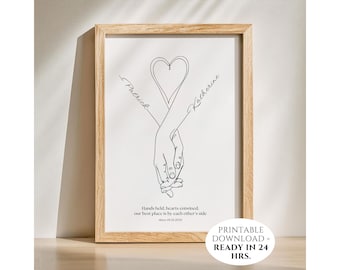 May include: A framed line art print featuring two hands intertwined, forming a heart shape. The names "Patrick" and "Katherine" are written on the arms. The text reads "Hands held, hearts entwined, our best place is by each other's side since 01.01.2023."