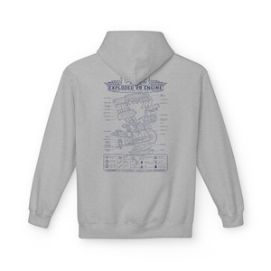 May include: A light gray hooded sweatshirt featuring a dark blue graphic on the back. The print displays an exploded view diagram of an LS3 V8 engine with technical labels and a specifications box at the bottom, including the text LS3 EXPLODED V8 ENGINE.