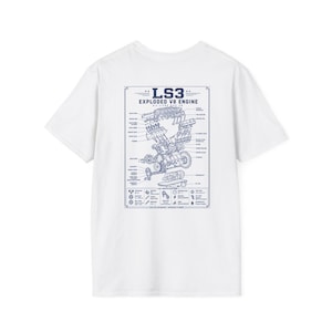 May include: A white t-shirt featuring a blue graphic print on the back. The design displays an exploded view of an LS3 V8 engine with technical labels, including the text LS3 EXPLODED V8 ENGINE and various engine component specifications.