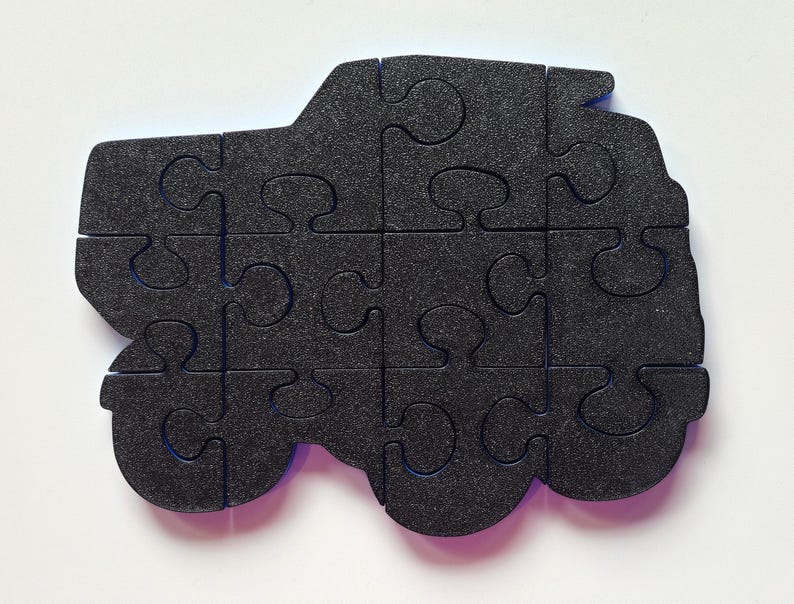 Może przedstawiać: Czarny element puzzli z pianki w kształcie samochodu z niebieskimi krawędziami. Puzzle składa się z 12 element&oacute;w.