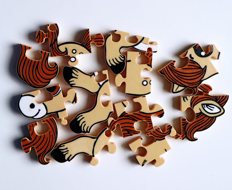 Op de afbeelding: Een voltooide puzzel met 15 stukjes, die een cartoonfiguur met bruin haar, een wit gezicht en bruine benen voorstelt. De puzzelstukjes zijn gemaakt van dik karton en hebben een glanzende afwerking.
