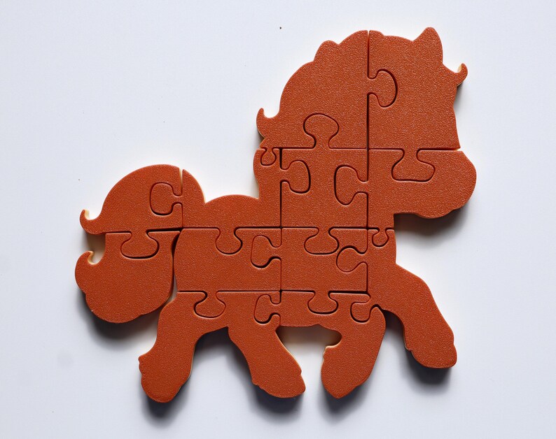 May include: A brown plastic puzzle of a horse with a mane and tail. The puzzle is made up of 10 pieces.