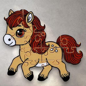 May include: A tan and white horse puzzle with a brown mane and tail. The puzzle is made of wood and has a jigsaw design.