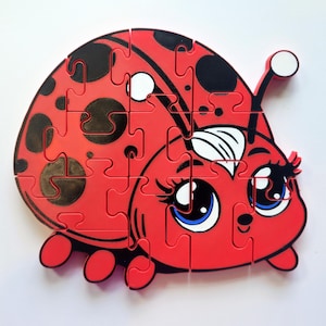 May include: A red ladybug puzzle with black spots and large, blue eyes. The puzzle is made of foam and has a 3D effect.