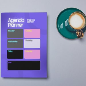 May include: Purple agenda planner with a geometric pattern. The planner has spaces for each day of the week, Monday through Sunday, and a notes section. The text "Agenda Planner" and "This is your agenda" are printed on the planner.