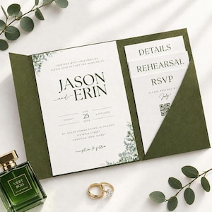 May include: A dark olive green wedding invitation folder containing a main card with the text Jason and Erin, Friday Aug 25 2026, and additional cards labeled Details, Rehearsal, and RSVP with a QR code, accompanied by a green perfume bottle and two gold rings.