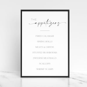 Puede incluir: Impresión enmarcada en blanco con borde negro. La impresión presenta la palabra "THE" encima de la palabra "appetizers" en cursiva. Debajo, una lista de aperitivos incluye calamares fritos, rollitos de primavera, carnes y quesos, champiñones rellenos, albóndigas suecas, vieiras y gambas al ajillo.