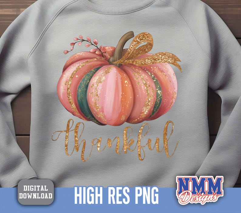 May include: A pale grey sweatshirt with a watercolour pumpkin design. The pumpkin is pink, orange, and green with gold glitter and a gold bow. The word "thankful" is written in gold script below the pumpkin.
