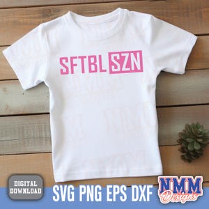 May include: White t-shirt with the text "SFTBL SZN" in pink letters.