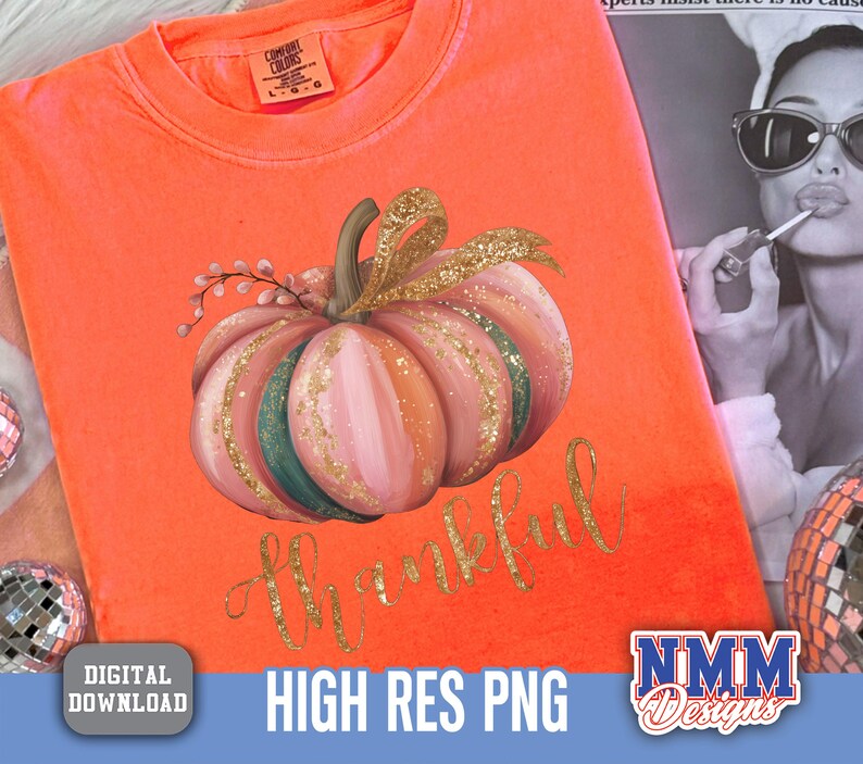 May include: Orange Comfort Colors t-shirt featuring a watercolour pumpkin design. The pumpkin is pink, green, and gold, with the word "thankful" in gold script. The shirt is a digital download.