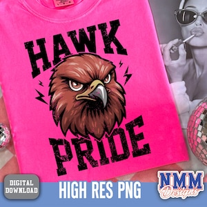 May include: A bright pink t-shirt featuring a detailed illustration of a hawk's head with the words "HAWK PRIDE" in bold, black letters. The design includes lightning bolt accents. The words "DIGITAL DOWNLOAD" and "HIGH RES PNG" are also visible.