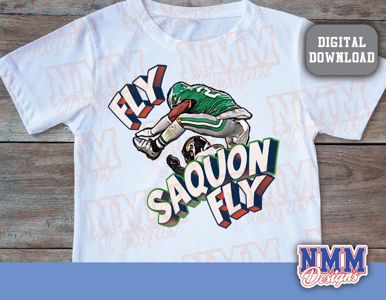K&ouml;nnte beinhalten: Wei&szlig;es T-Shirt mit einer Grafik eines Footballspielers in gr&uuml;n-wei&szlig;er Uniform und den Worten "FLY SAQUON FLY" in 3D-Schrift. Das Design enth&auml;lt ein "DIGITAL DOWNLOAD"-Etikett.