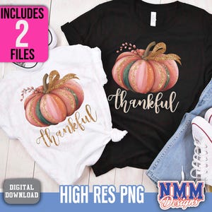 May include: Two t-shirts, one black and one white, each with a watercolour pumpkin design and the word "thankful" in gold script. The pumpkins are pink, orange, and green with gold glitter. The image includes the text "Includes 2 Files" and "High Res PNG".