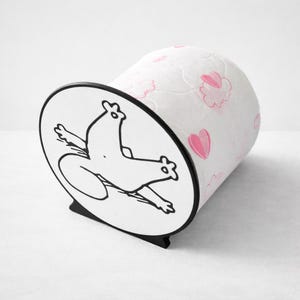 Può includere: Un portarotolo di carta igienica bianco e nero con un design a forma di rana dei cartoni animati. Il supporto ha una base nera e un corpo cilindrico bianco decorato con cuori e forme di nuvole rosa.
