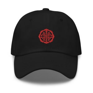 May include: A black baseball cap with a red embroidered geometric design on the front.