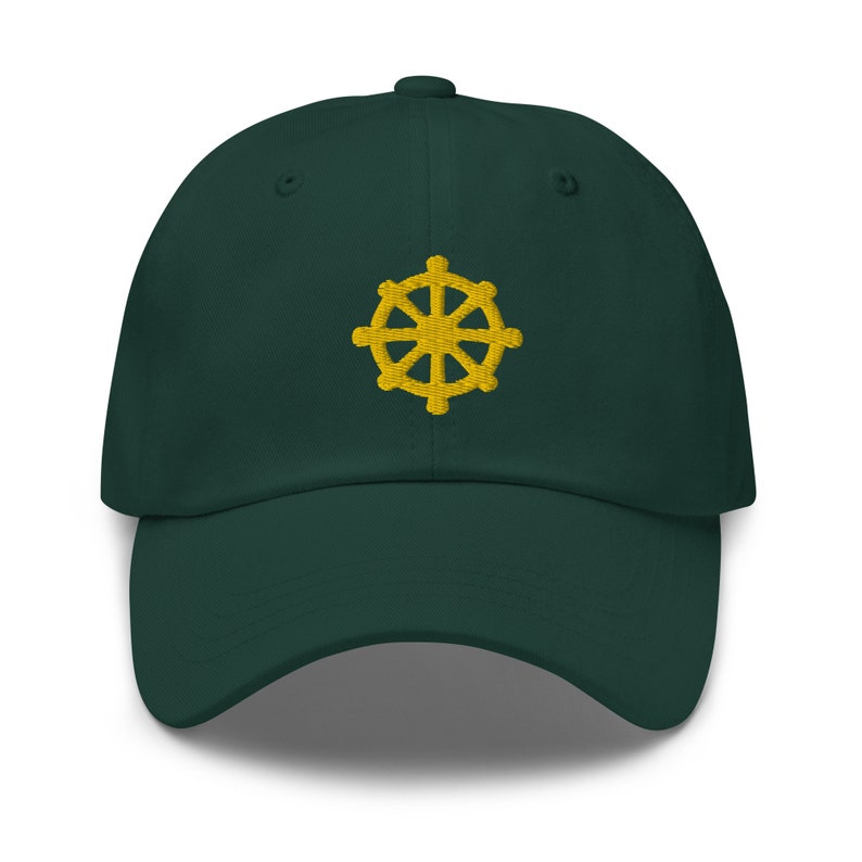 Puede incluir: Una gorra de b&eacute;isbol verde oscuro con un s&iacute;mbolo Dharmachakra bordado en oro.