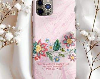 Könnte beinhalten: Rosa Handyhülle mit Marmormuster und floralen Akzenten. Die Hülle hat einen farbenfrohen Blumenrand mit roten, blauen und gelben Blumen. Der Text auf der Hülle lautet: "Glaube wie ein Senfkorn kann Berge versetzen." -Matthäus 17,20.