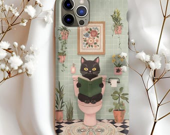Könnte beinhalten: Eine Handyhülle mit einer skurrilen Illustration einer schwarzen Katze, die ein Buch liest, während sie auf einer rosa Toilette sitzt. Der Hintergrund zeigt einen gerahmten Blumendruck, Topfpflanzen und einen schwarz-weiß karierten Boden. Die Hülle hat einen hellgrünen Hintergrund.