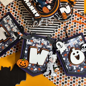May include: Halloween-themed banner with Mickey Mouse characters. The banner features the numbers "one" and "two" with a black and orange polka dot background. The banner is decorated with bats, pumpkins, ghosts, and spiders.