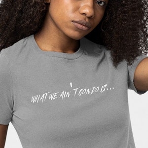 May include: A gray t-shirt with the text "What we ain't gon' do is..." printed in white.
