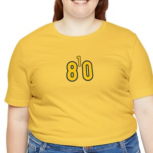 May include: A yellow short-sleeved t-shirt with the text "8'0" printed on the front in black and yellow.