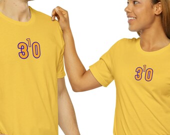 May include: Two people wearing matching yellow t-shirts with the text "3'0" printed on the front. The t-shirts have a relaxed fit and short sleeves.
