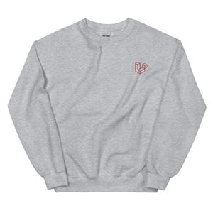 Könnte beinhalten: Ein graues Sweatshirt mit einem roten gestickten Logo eines stilisierten Würfels auf der linken Brust.