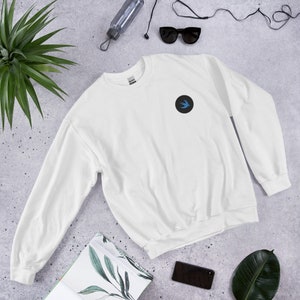 May include: White sweatshirt with a blue bird logo in a black circle on the left chest.