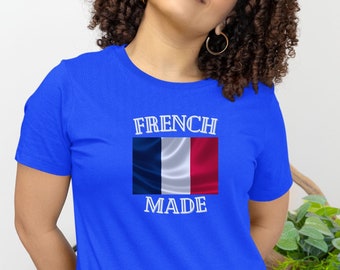Puede incluir: Una camiseta azul real con un gráfico blanco de la bandera francesa y el texto "French Made".