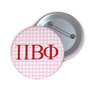 May include: A pink and white gingham button with the letters "ПВФ" in red.