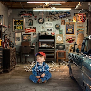 Puede incluir: Un niño pequeño con un mono azul y una gorra de béisbol roja se sienta en el suelo de un garaje desordenado. El garaje está decorado con carteles y pósters vintage, y un coche clásico está aparcado en el fondo.