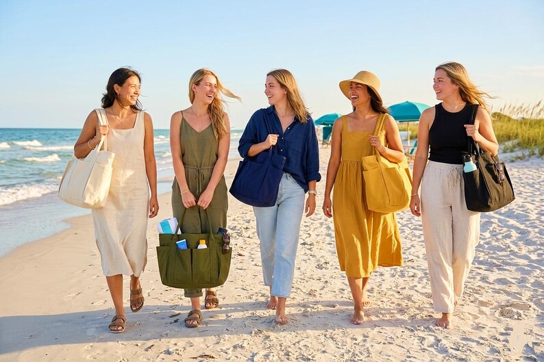 Puede incluir: Cinco personas caminando por una playa de arena, cada una llevando un bolso tote. Los bolsos son de varios colores, incluyendo crema, verde oliva, azul marino, amarillo mostaza y negro. Llevan ropa informal de verano.