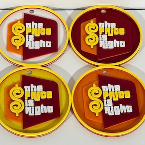 Puede incluir: Cuatro posavasos redondos con el texto "the Price is Right". Cada posavasos tiene un borde amarillo, con un diseño rojo y naranja. El texto y el signo de dólar son amarillos y blancos.