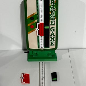 Op de afbeelding: Een groen en wit range-spel met een rode schuifregelaar en een zwart digitaal display. Het spel is op een wit oppervlak met een witte liniaal en een zwart rechthoek.