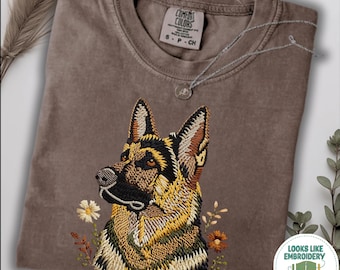 Puede incluir: Una camiseta color espresso con un gráfico detallado de un perro pastor alemán rodeado de pequeñas flores. La prenda tiene cuello redondo y una etiqueta que dice Comfort Colors. Una insignia circular indica Looks Like Embroidery But It's Printed.