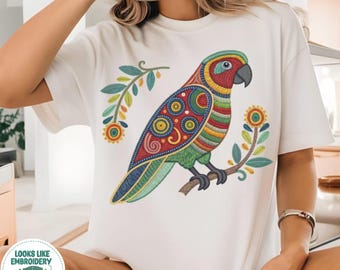 May include: A white short-sleeve t-shirt featuring a colorful graphic of a parrot perched on a branch. The parrot has intricate red, green, yellow, and blue patterns. A small circular badge in the corner reads: LOOKS LIKE EMBROIDERY BUT IT'S PRINTED!