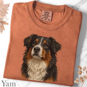 Peut inclure: Un t-shirt Comfort Colors de couleur terre cuite avec un portrait détaillé d'un bouvier bernois. Le chien a des poils noirs, bruns et blancs. Le t-shirt a un col côtelé et une étiquette qui indique "Comfort Colors" et "XL - TG - EG".